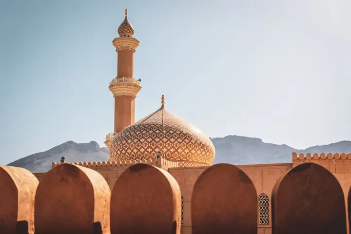 Runder Verteidigungsturm des Forts von Nizwa über den Palmenhainen, Oman