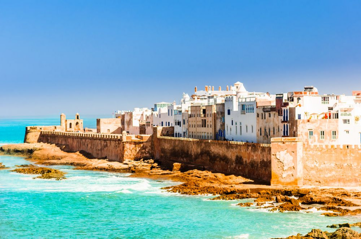 Weiß-blaue Altstadt von Essaouira hinter der historischen Stadtmauer am türkisfarbenen Atlantik, Marokko Weiß-blaue Altstadt von Essaouira hinter der historischen Stadtmauer am türkisfarbenen Atlantik, Marokko