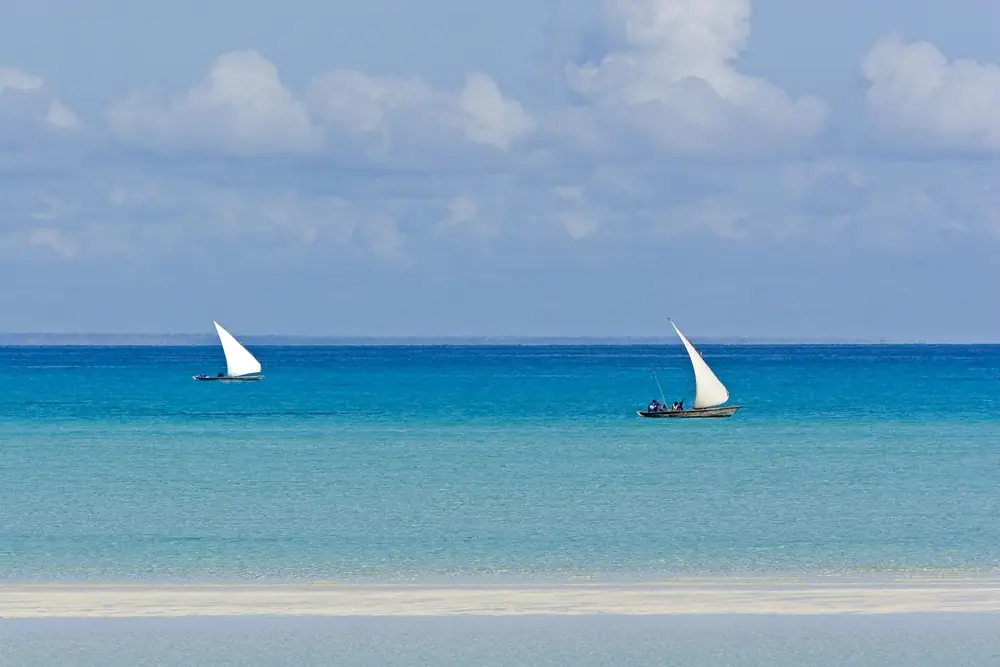 Zwei traditionelle Dhows mit weißen Segeln auf dem türkisfarbenen Indischen Ozean vor der Küste Mosambiks Zwei traditionelle Dhows mit weißen Segeln auf dem türkisfarbenen Indischen Ozean vor der Küste Mosambiks