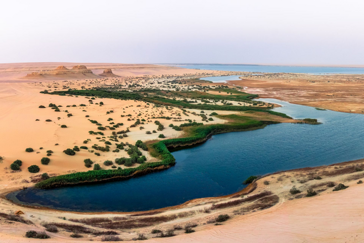 See von Fayoum mit türkisem Wasser zwischen Sanddünen und dem Al-Madawara-Berg in der Wüste Ägyptens See von Fayoum mit türkisem Wasser zwischen Sanddünen und dem Al-Madawara-Berg in der Wüste Ägyptens