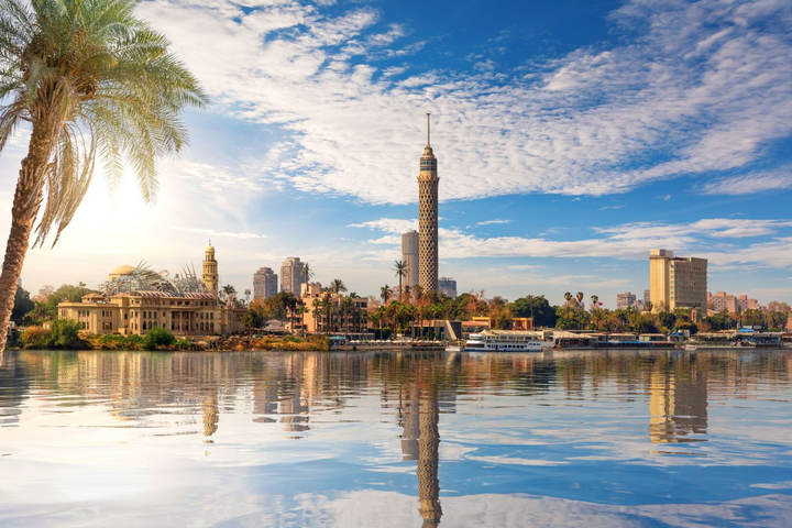 Skyline von Kairo mit Cairo Tower und Palmen am Nilufer, gespiegelt im Wasser — Luxusreise Ägypten Skyline von Kairo mit Cairo Tower und Palmen am Nilufer, gespiegelt im Wasser — Luxusreise Ägypten